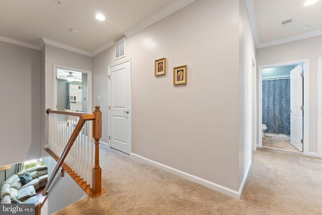 hall with crown molding, light carpet, and an upstairs landing