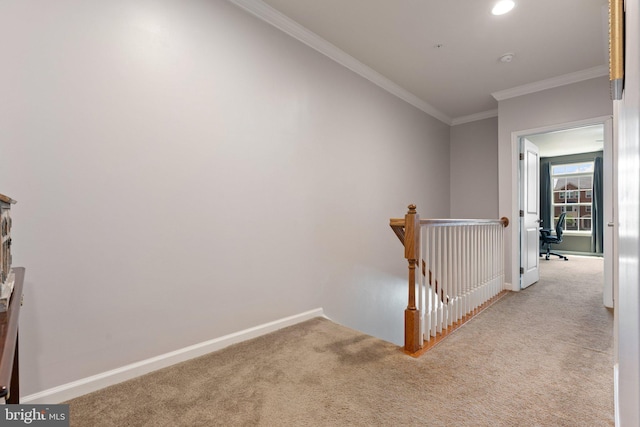 hallway with carpet flooring, crown molding, an upstairs landing, and baseboards
