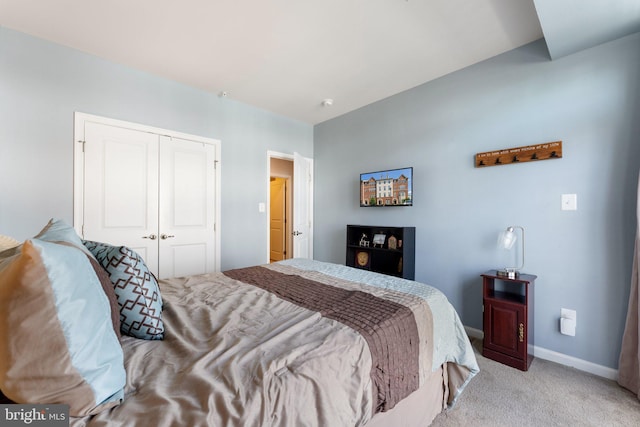 bedroom featuring light colored carpet, baseboards, and a closet