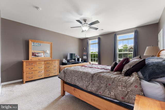 carpeted bedroom with visible vents, baseboards, and ceiling fan