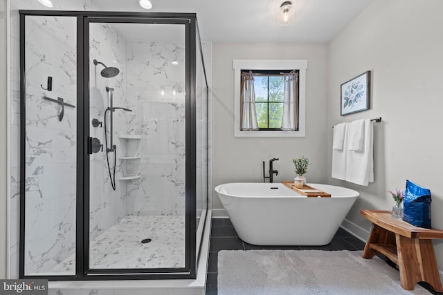 bathroom featuring a marble finish shower, baseboards, a soaking tub, and tile patterned flooring