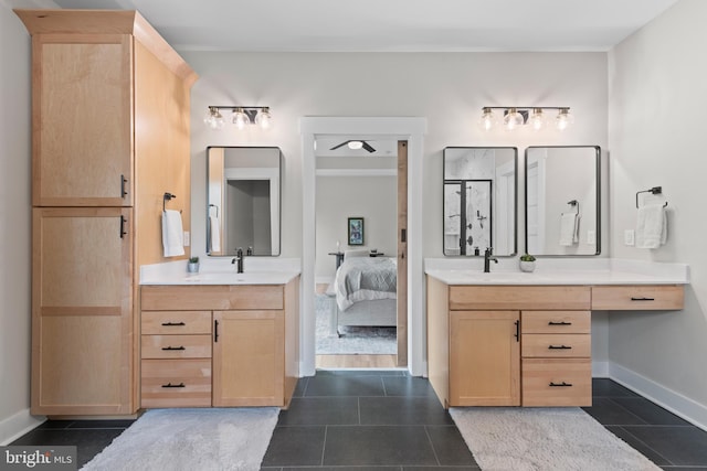 bathroom with a sink, baseboards, ensuite bath, and two vanities