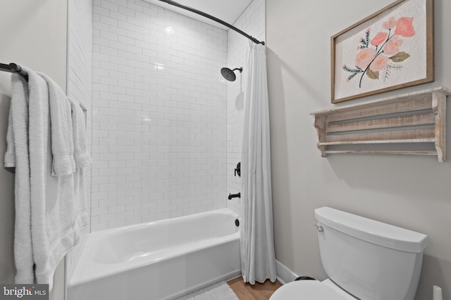 bathroom with shower / tub combo with curtain, wood finished floors, and toilet