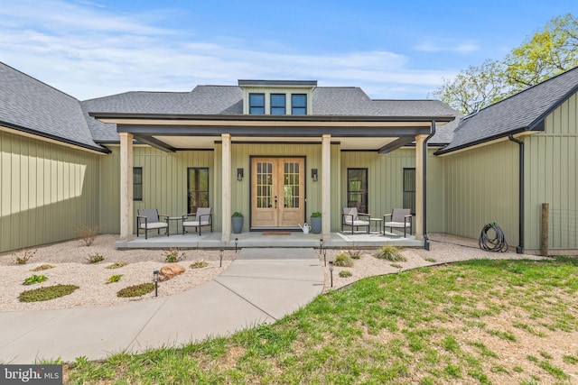 doorway to property with a porch, roof with shingles, and french doors