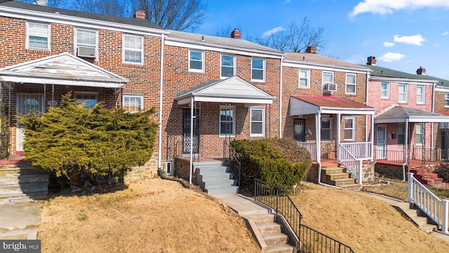 view of front of house with a chimney and brick siding