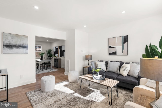 living area with baseboards, recessed lighting, and wood finished floors