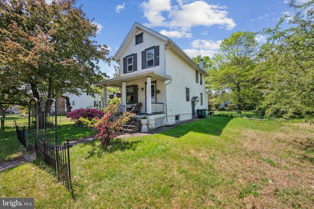 view of front of property featuring covered porch, fence, and a front yard