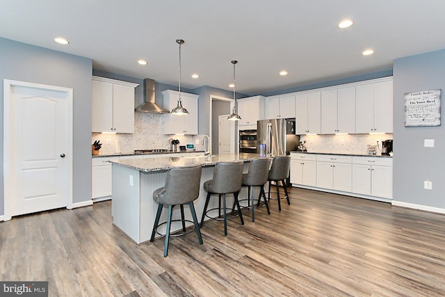 108 Chimney Swift Rd, Fredericksburg, VA 22406 - kitchen with wall chimney range hood, backsplash, appliances with stainless steel finishes, and a breakfast bar