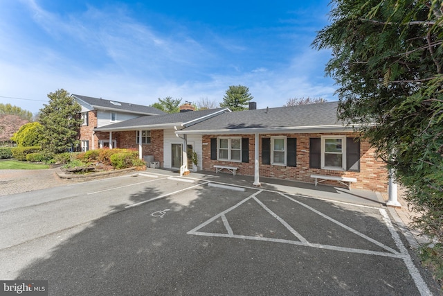 610 Valley Brook Dr, Silver Spring, MD 20904 - view of front facade with a chimney, uncovered parking, and brick siding