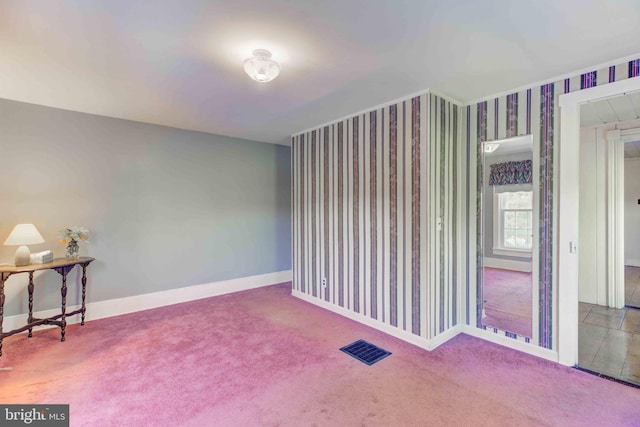 carpeted empty room featuring baseboards and wallpapered walls