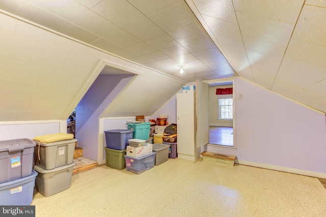 additional living space featuring baseboards and lofted ceiling