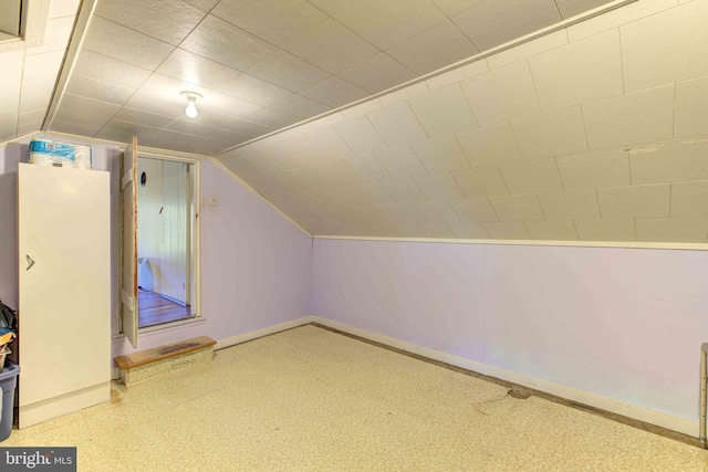 additional living space with baseboards and lofted ceiling