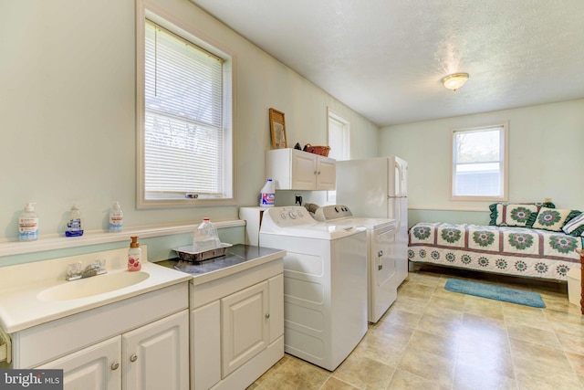 laundry area featuring washing machine and clothes dryer and cabinet space