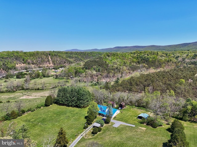 aerial overview of property's location featuring a forest and mountains