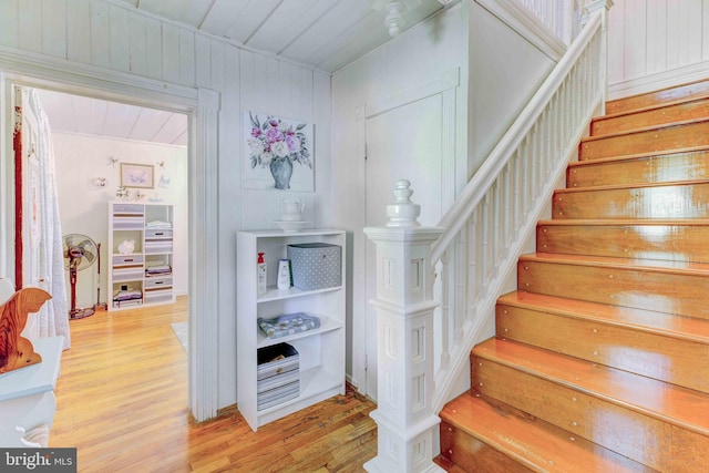 staircase featuring wood finished floors and wood ceiling