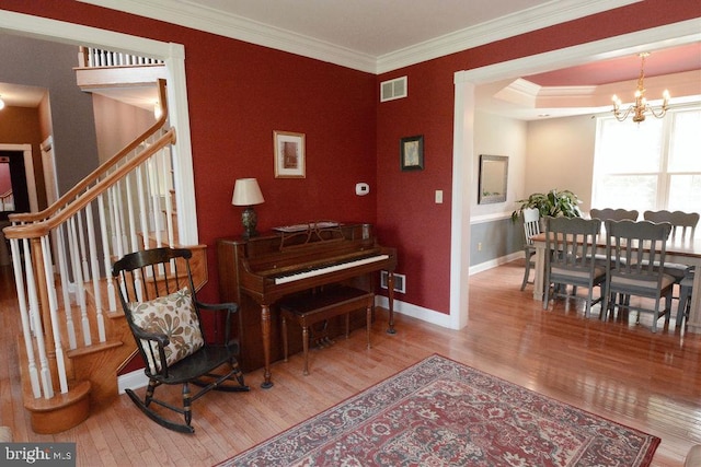 2350 Josie Ln, Harleysville, PA 19438 - living area with a notable chandelier, crown molding, visible vents, baseboards, and wood finished floors