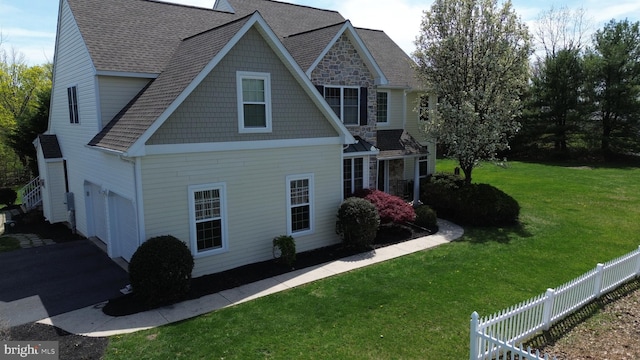 2350 Josie Ln, Harleysville, PA 19438 - view of side of home with aphalt driveway, a shingled roof, fence, a yard, and a garage
