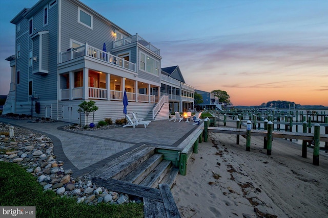 29710 Seagrass Ct, Dagsboro, DE 19939 - back of property at dusk with a patio area, stairway, and a balcony