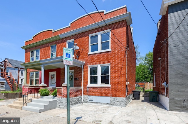 view of front of home featuring brick siding and covered porch