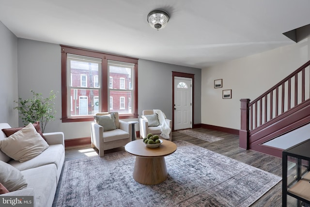 foyer entrance featuring baseboards, stairs, and wood finished floors