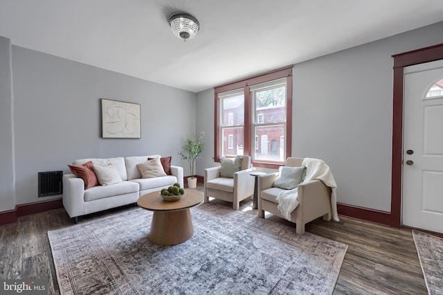 living room featuring baseboards, visible vents, and dark wood-style floors