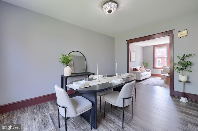dining space featuring baseboards and wood finished floors