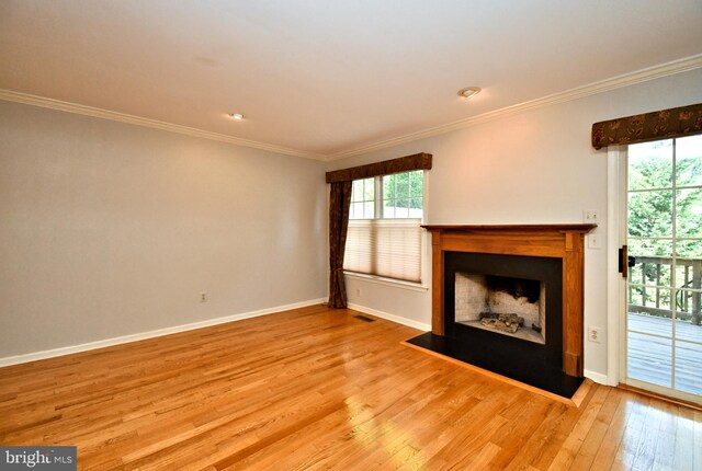 unfurnished living room featuring crown molding, visible vents, baseboards, a fireplace with flush hearth, and light wood-style flooring