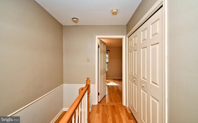 hall featuring an upstairs landing and light wood-style flooring