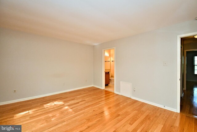 empty room featuring baseboards and light wood-style flooring