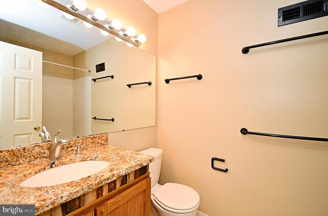 full bath with vanity, baseboards, toilet, and visible vents