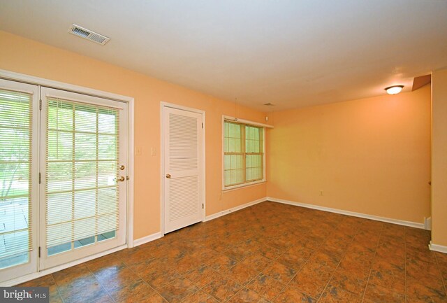 spare room featuring baseboards and visible vents