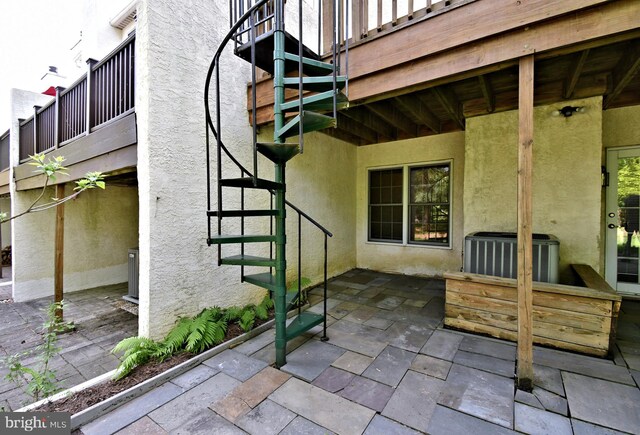 view of patio / terrace with cooling unit and stairway
