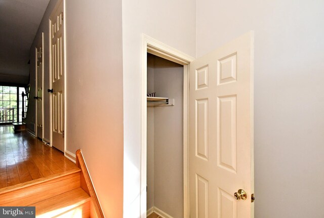 hallway featuring baseboards and hardwood / wood-style flooring