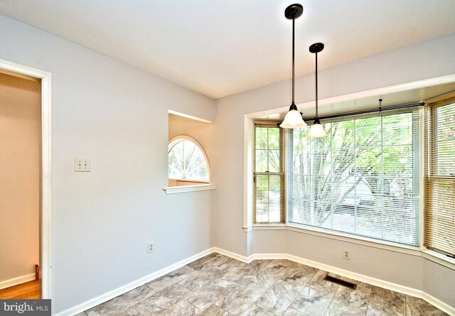 unfurnished dining area featuring baseboards and visible vents