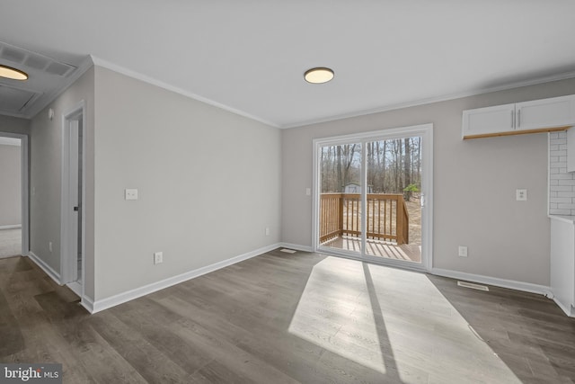 empty room featuring baseboards, visible vents, ornamental molding, and dark wood-type flooring