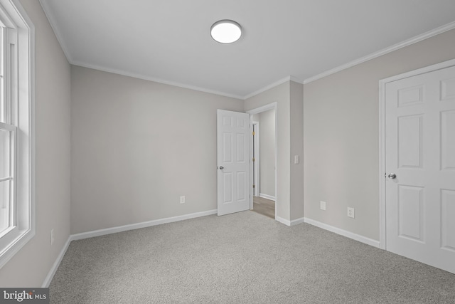 unfurnished bedroom featuring baseboards, ornamental molding, and carpet flooring