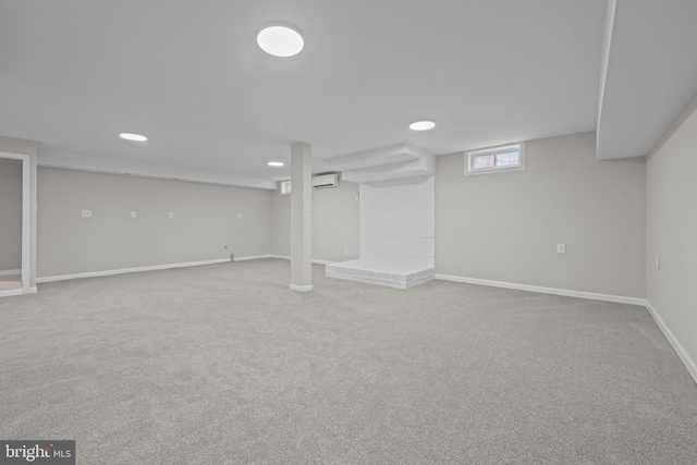 below grade area featuring baseboards, recessed lighting, carpet floors, and an AC wall unit