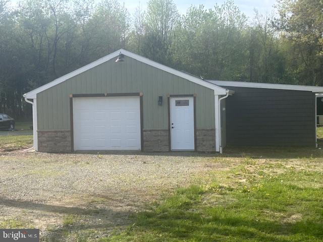 detached garage featuring dirt driveway