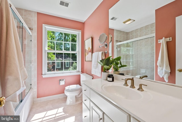 bathroom with tile patterned flooring, vanity, toilet, tiled shower / bath combo, and visible vents
