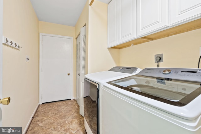 clothes washing area featuring cabinet space, baseboards, and washer and clothes dryer