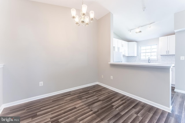 645 Constellation Sq SE Unit L, Leesburg, VA 20175 - unfurnished dining area featuring vaulted ceiling, track lighting, baseboards, dark wood-style floors, and an inviting chandelier