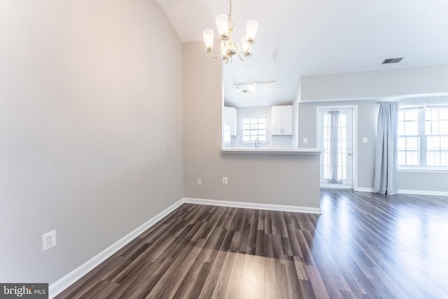 645 Constellation Sq SE Unit L, Leesburg, VA 20175 - unfurnished living room with visible vents, plenty of natural light, dark wood-style floors, and an inviting chandelier