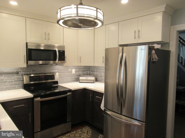 kitchen featuring white cabinetry, stainless steel appliances, backsplash, and light countertops