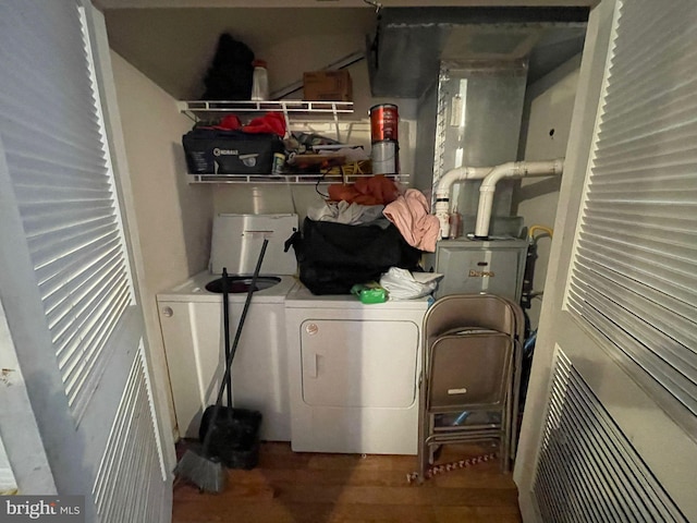 laundry room featuring separate washer and dryer, wood finished floors, and laundry area
