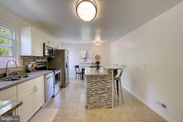 kitchen featuring a sink, visible vents, appliances with stainless steel finishes, and white cabinetry