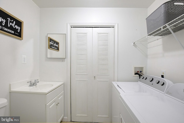 clothes washing area with a sink and washer and clothes dryer