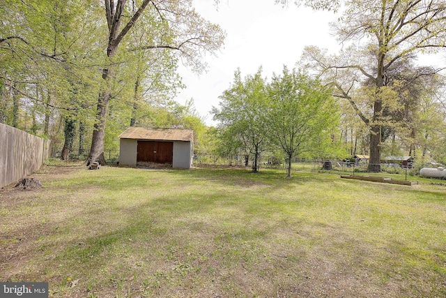 view of yard featuring an outbuilding, a storage shed, and fence