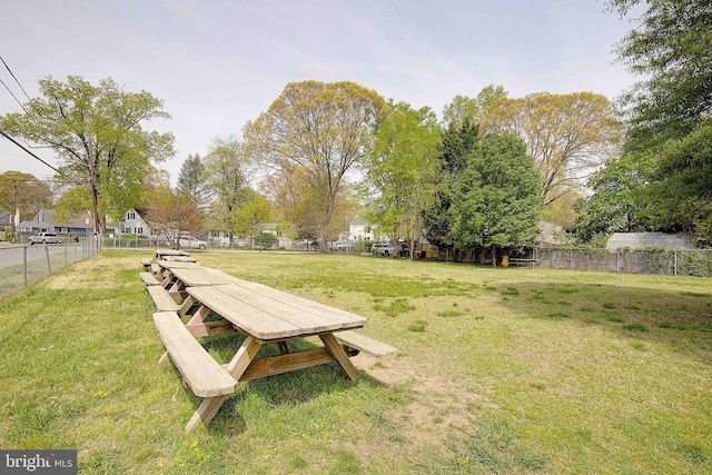 view of home's community with fence and a lawn