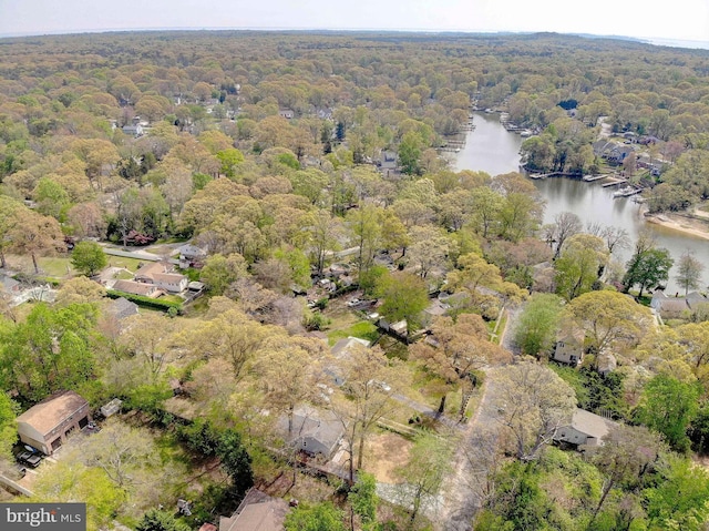 drone / aerial view with a wooded view and a water view