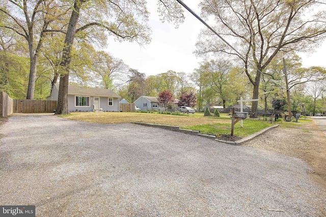 view of yard featuring fence and driveway